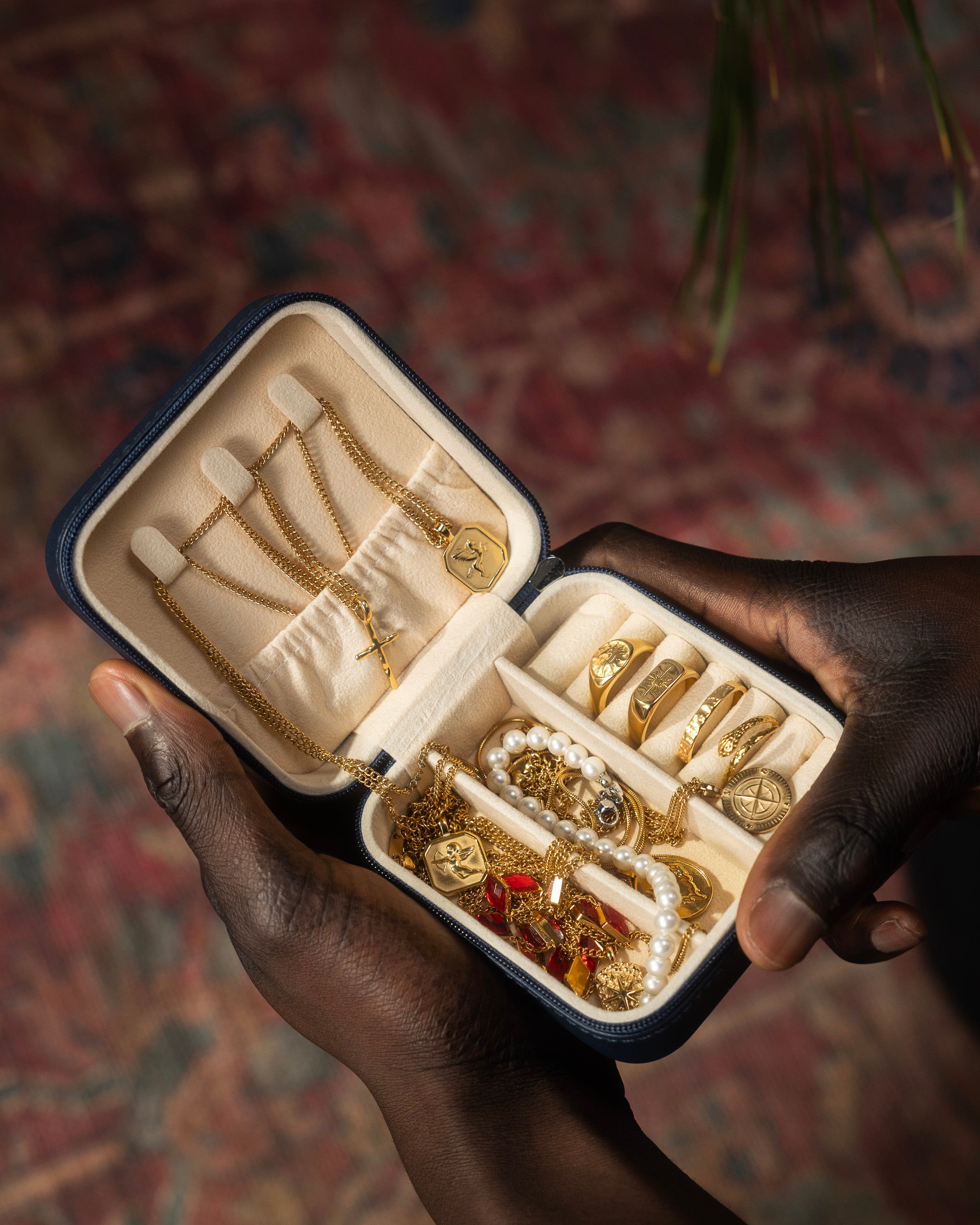 Open jewelry box full of gold chains and rings on a wooden surface