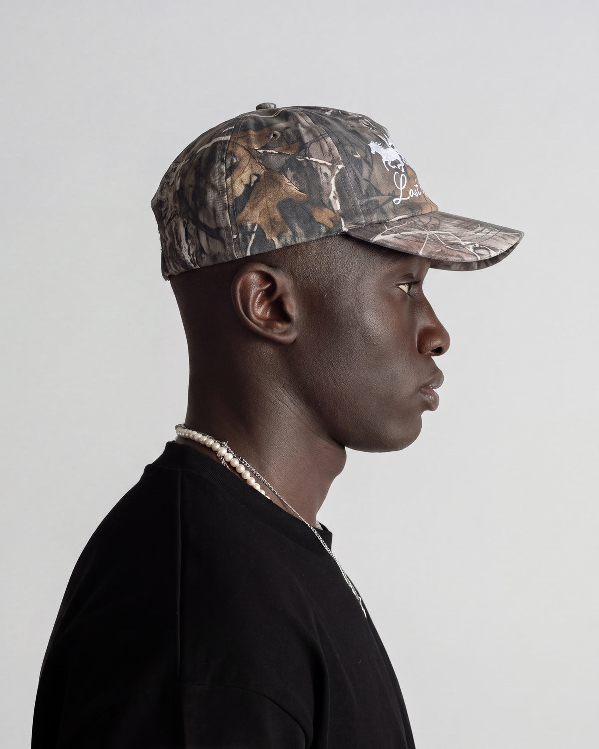Camouflage baseball cap shown in side profile with woodland pattern