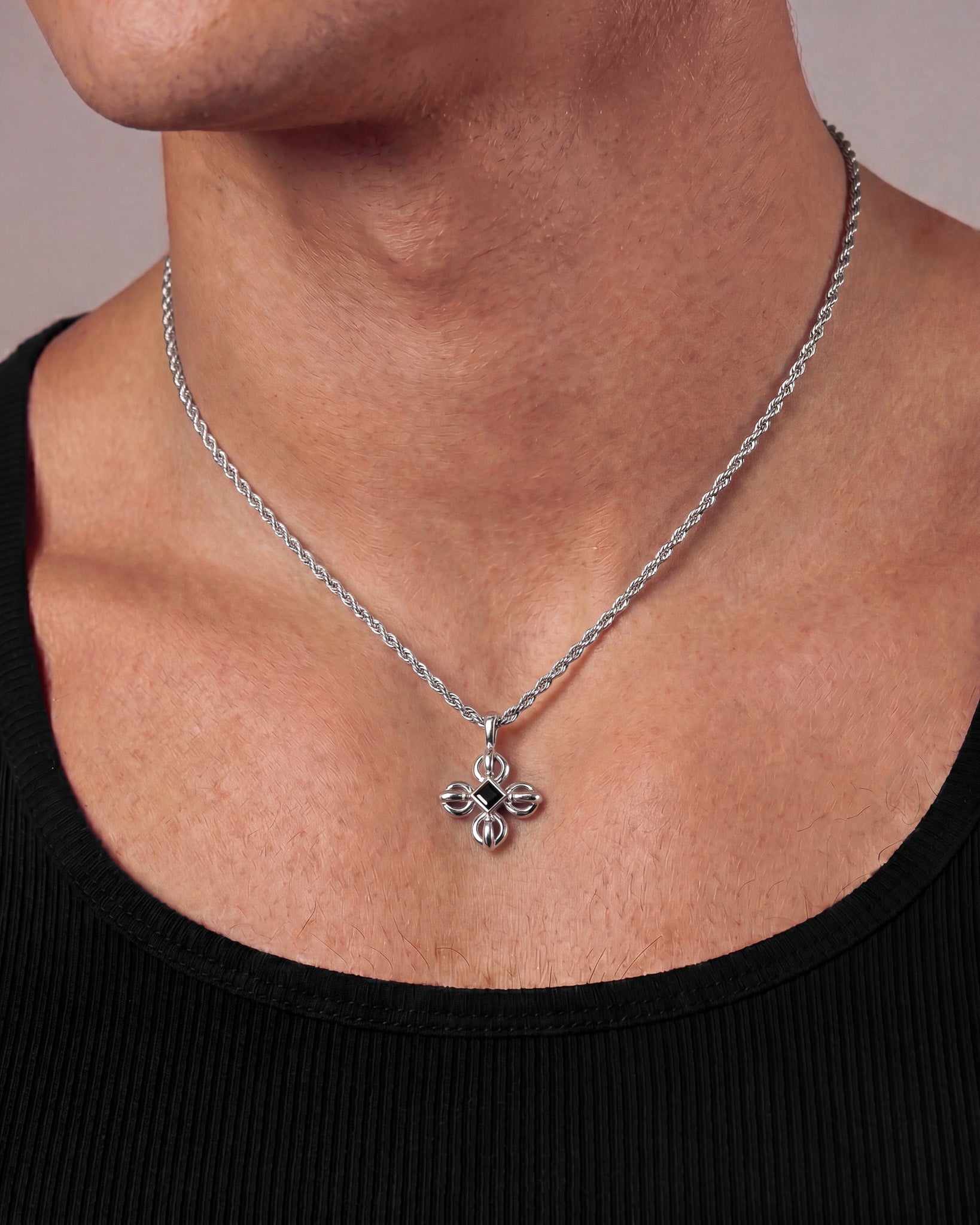 Close up of a man wearing the flare silver necklace showing the pendant at the throat