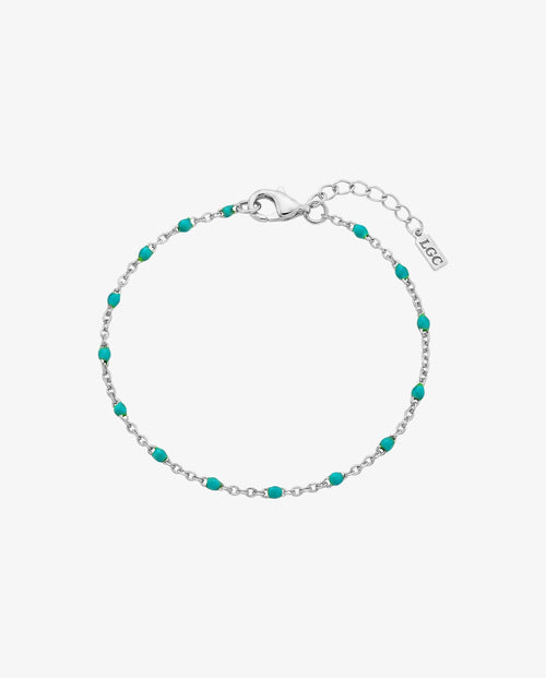 Silver bracelet with turquoise beads and a lobster clasp on a wrist