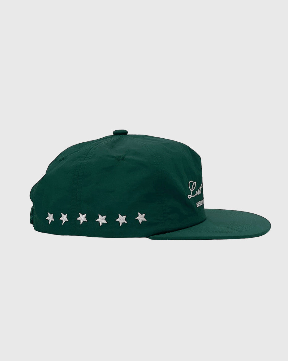 Three quarter view of a green nylon cap with embroidered logo on the front and star accents along the back.