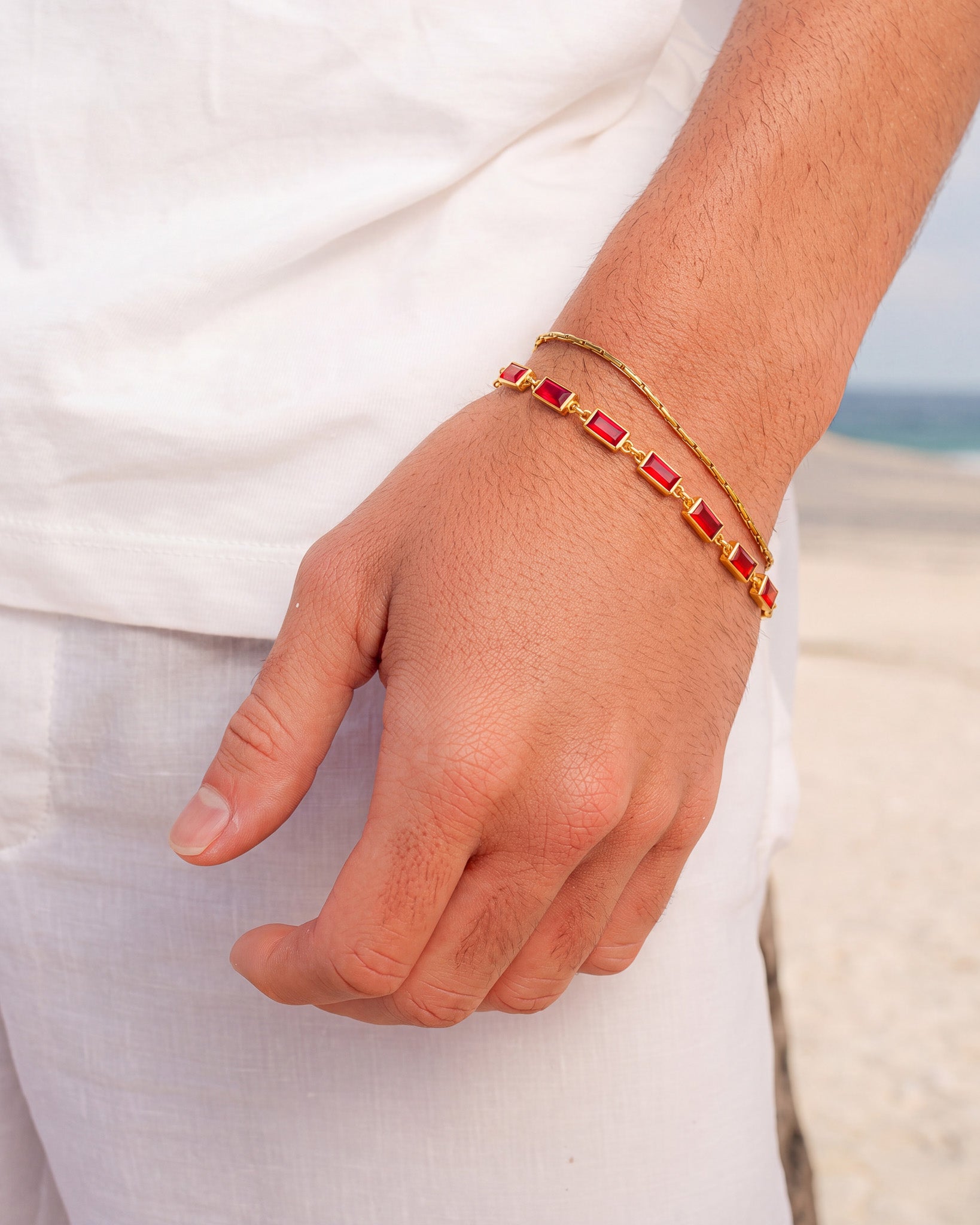 OMEN Gold Bracelet with red rectangular gemstones on a wrist showing the clasp